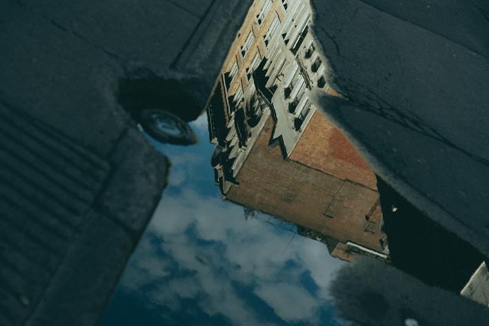 Reflexion eines alten Backsteingebäudes im Wasser - Symbol für Wahrnehmung, Perspektivwechsel und gesellschaftliches Nachdenken