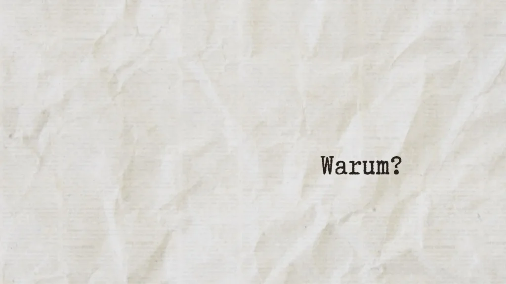 Das Wort „Warum?“ auf hellem Papier als Symbol für fragendes Denken